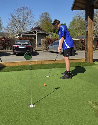Camper practicing on the putting green at the campsite in Brière