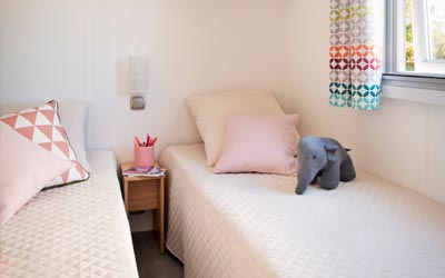 Chambre avec deux lits simples dans un mobil-home au camping les Chalands Fleuris